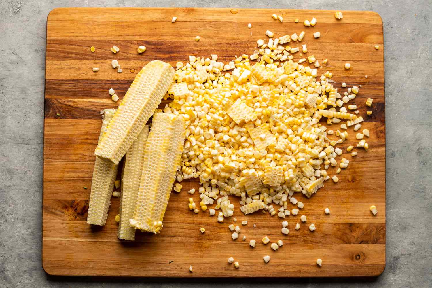 Cut the kernels off the corn cobs on the cutting board 