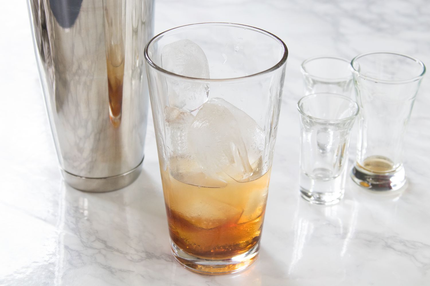 Amaretto sour ingredients mixed together in a glass with ice