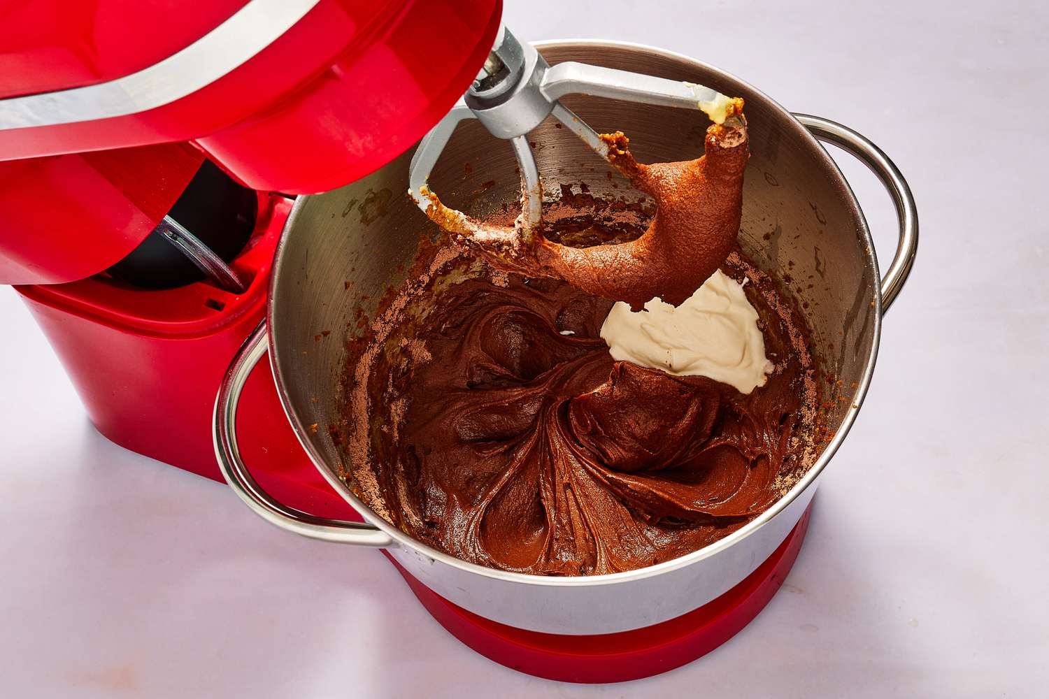 sour cream added to bowl of stand mixer with chocolate cake batter