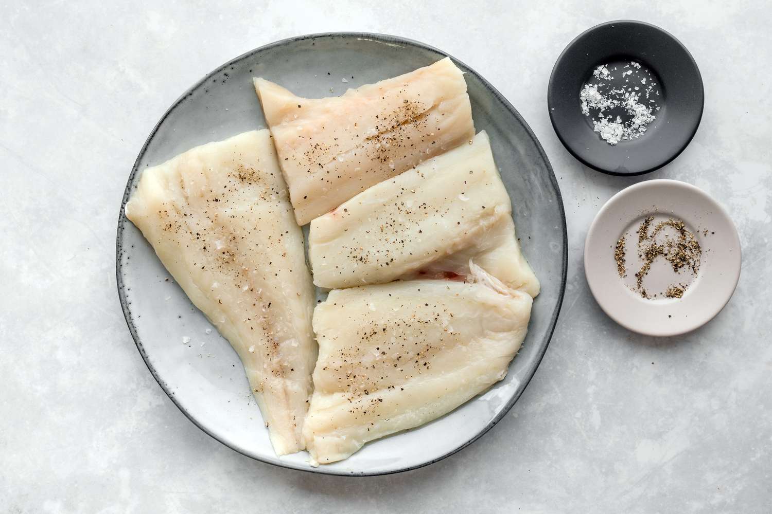 Haddock sprinkled with seasoning before breading and baking