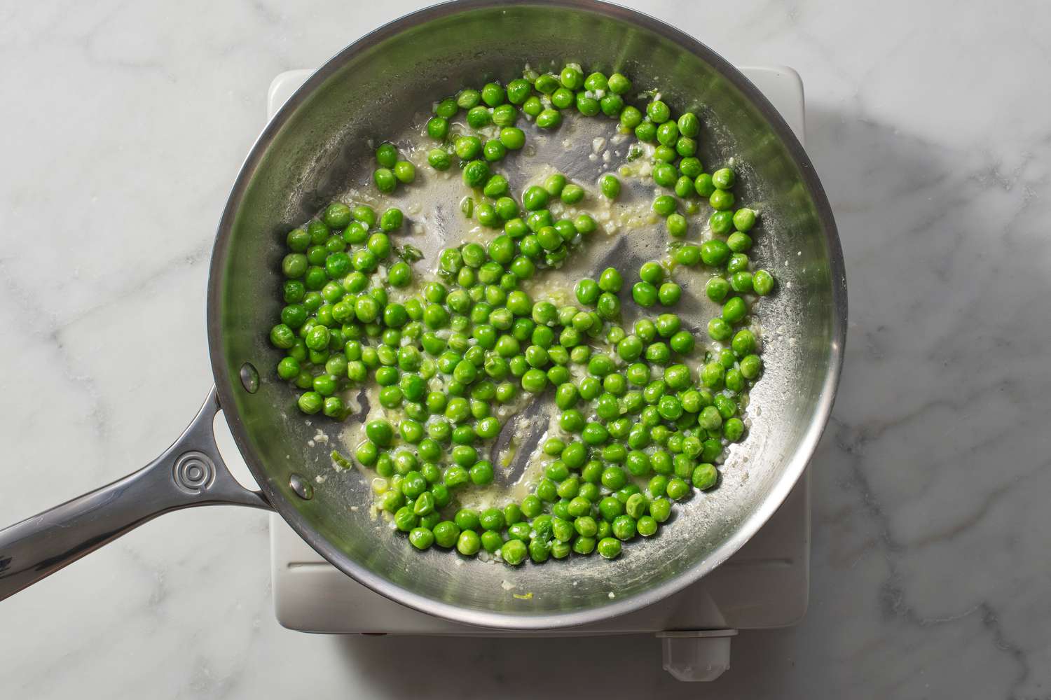 Water added to the pan of cooking peas