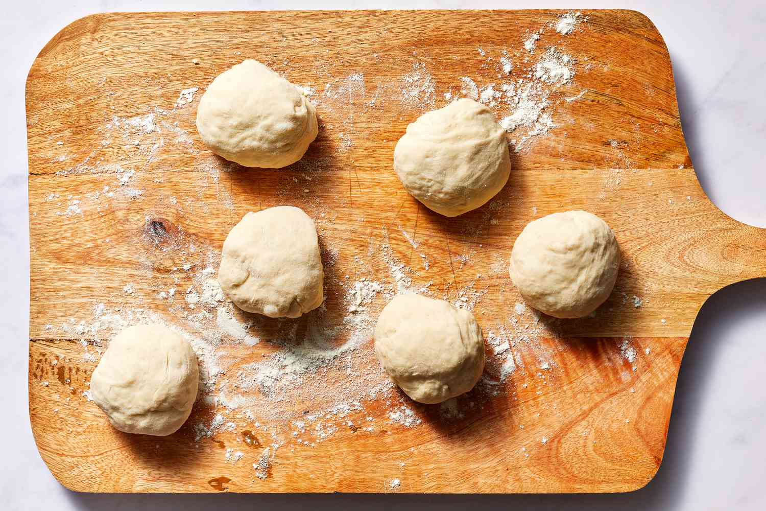 Dough balls on a floured cutting board 