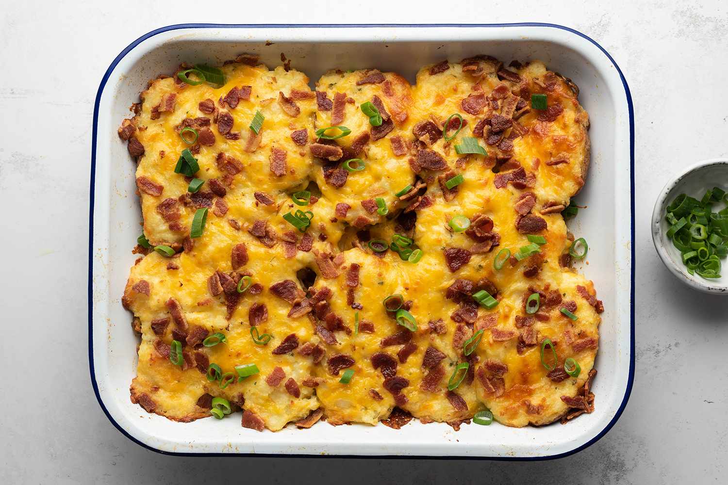Twice Baked Potato Casserole in a baking dish, garnished with green onions