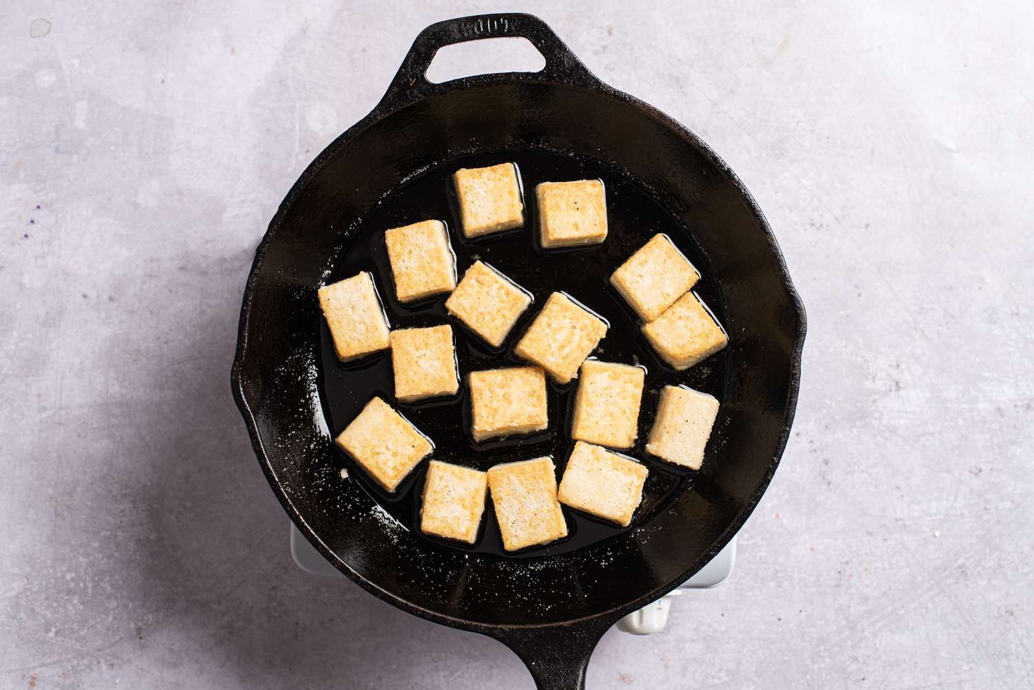 Browned tofu frying in a pan