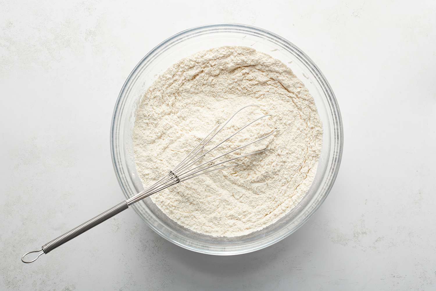 flour in a bowl with a metal whisk