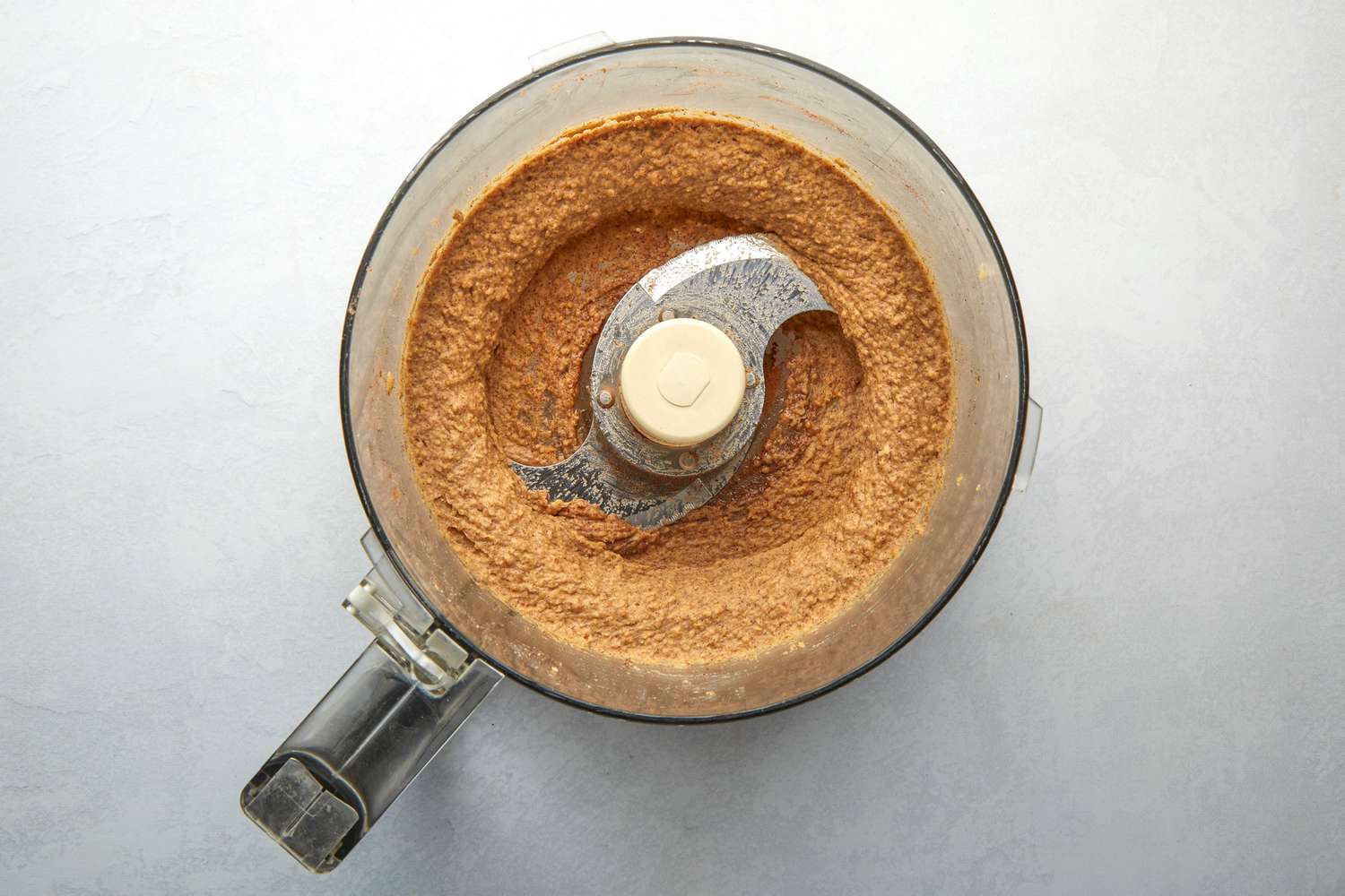 A food processor with smooth snickerdoodle hummus