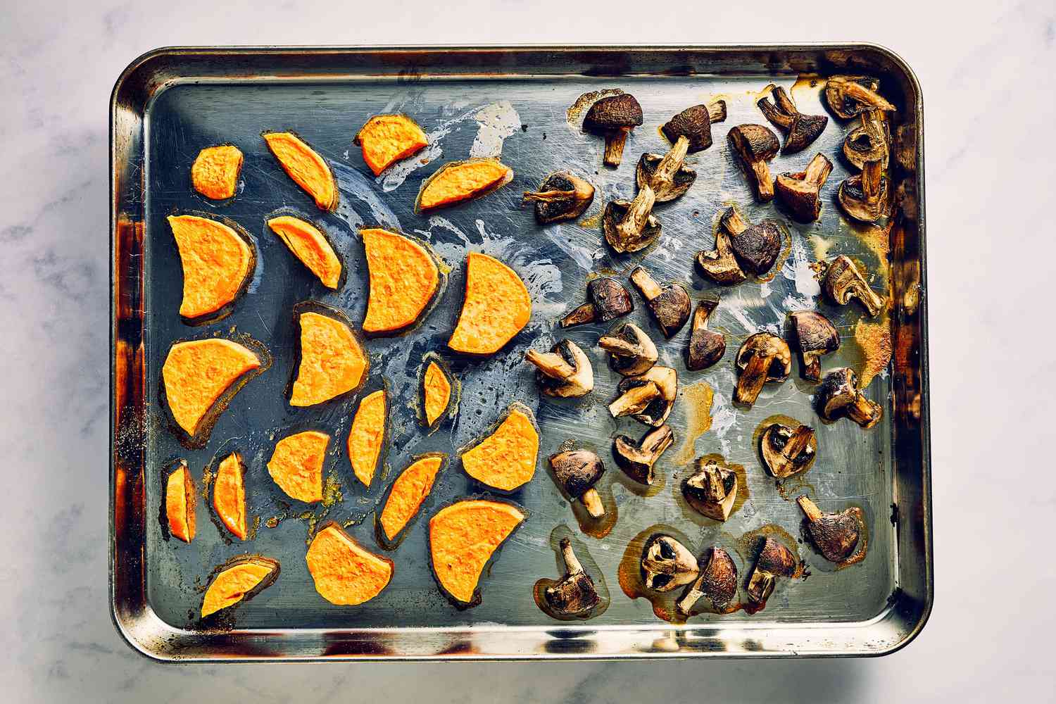 A sheet pan of roasted sweet potatoes and roasted cremini mushrooms