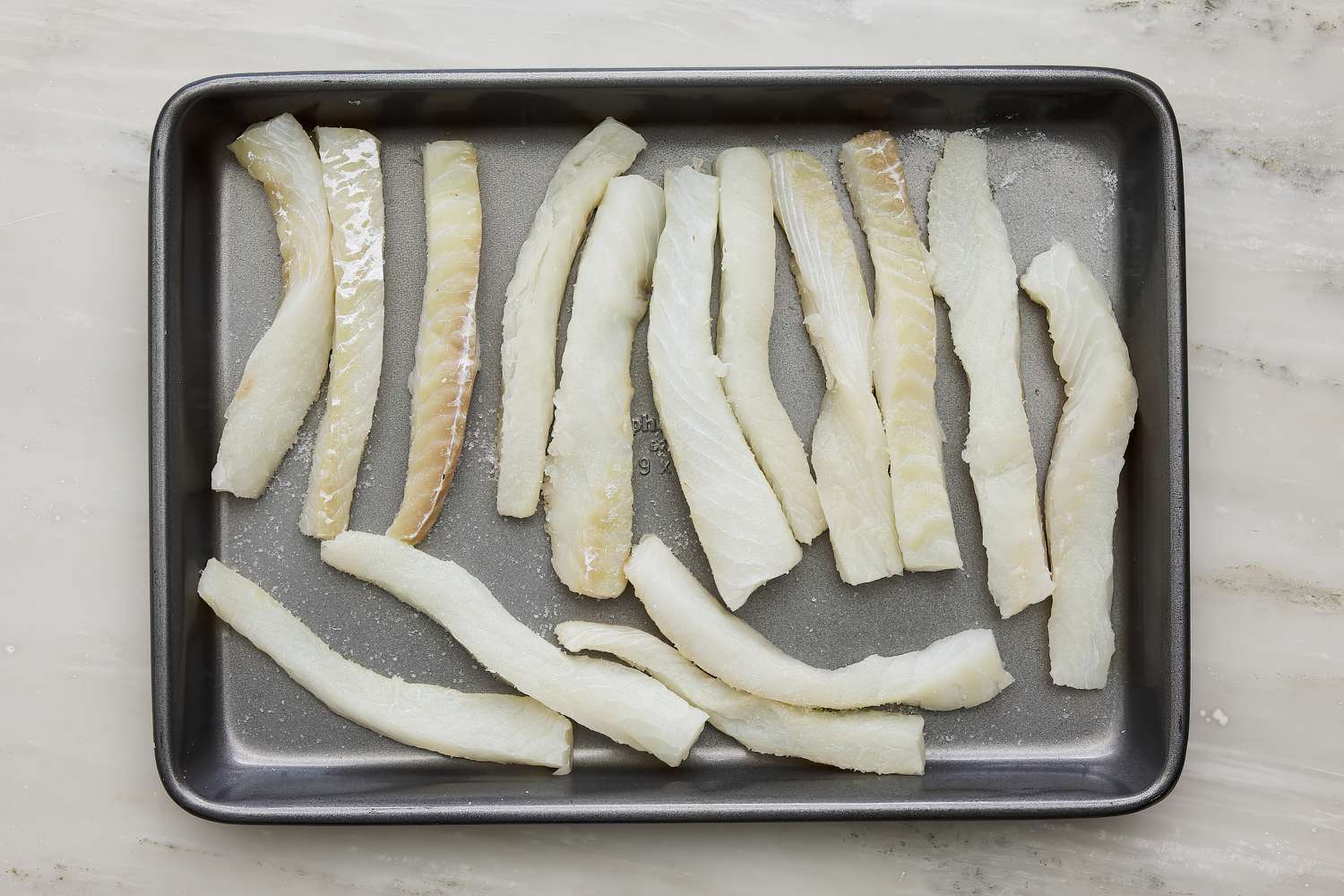 strips of cod on a baking sheet