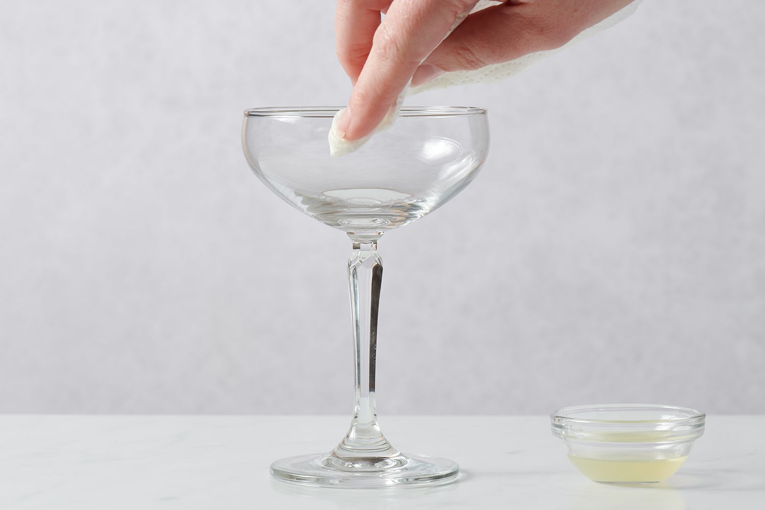 Rubbing the rim of a cocktail glass with lemon juice