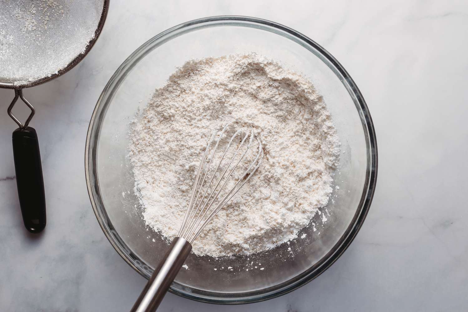 Almond flour, confectioners' sugar, and salt being stirred together in a bowl