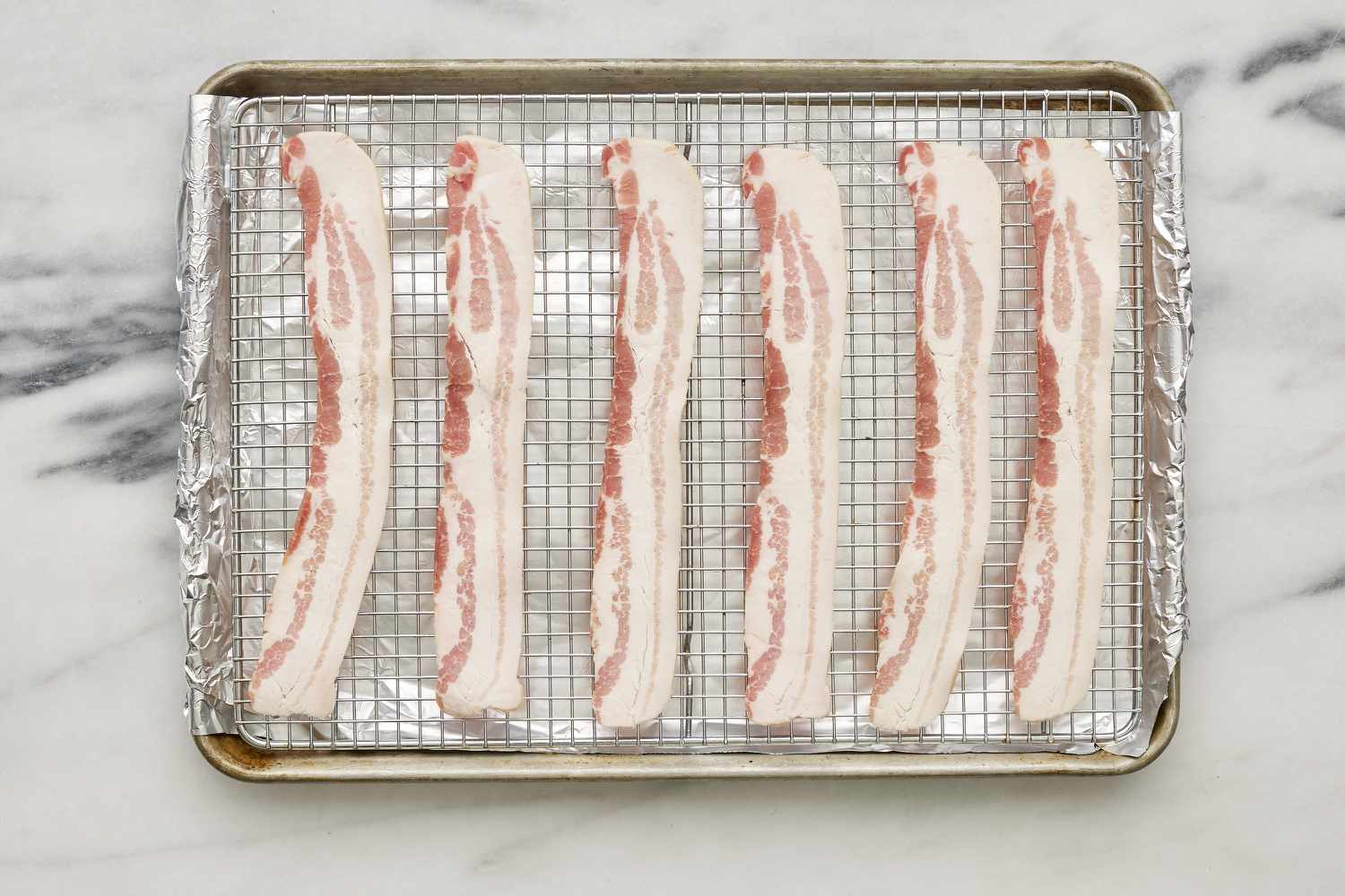 bacon on rack resting on foil lined baking sheet