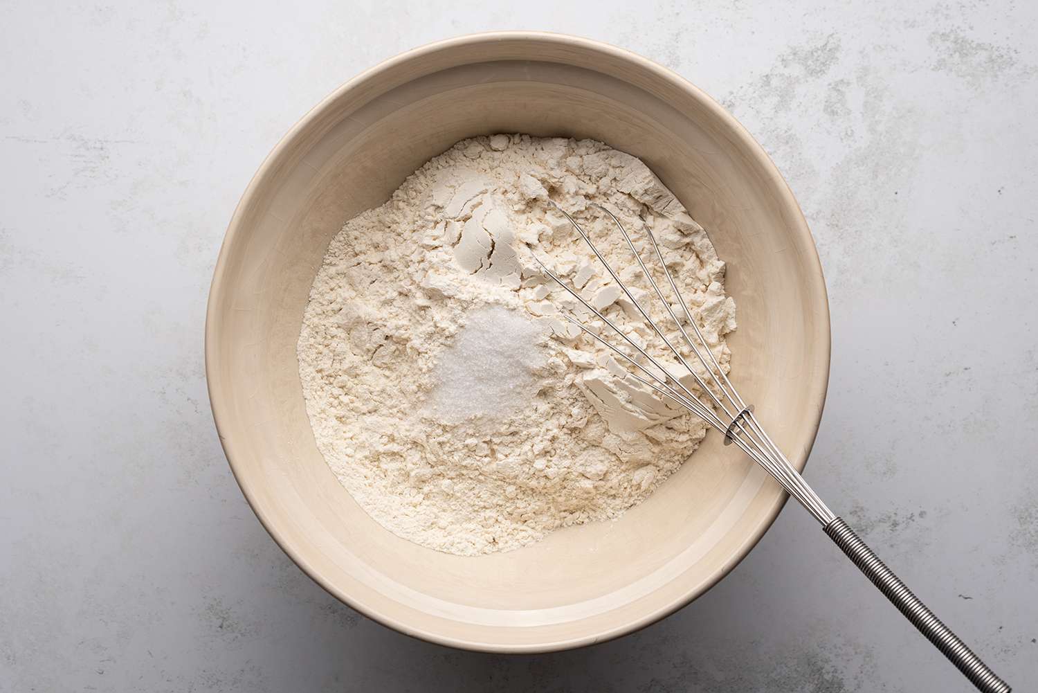 Flour and salt in a bowl with a whisk 