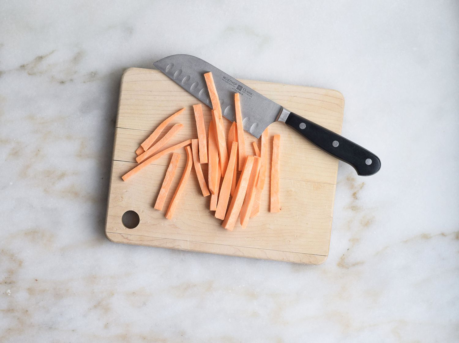 Sweet potatoes cut into matchsticks on a cutting board