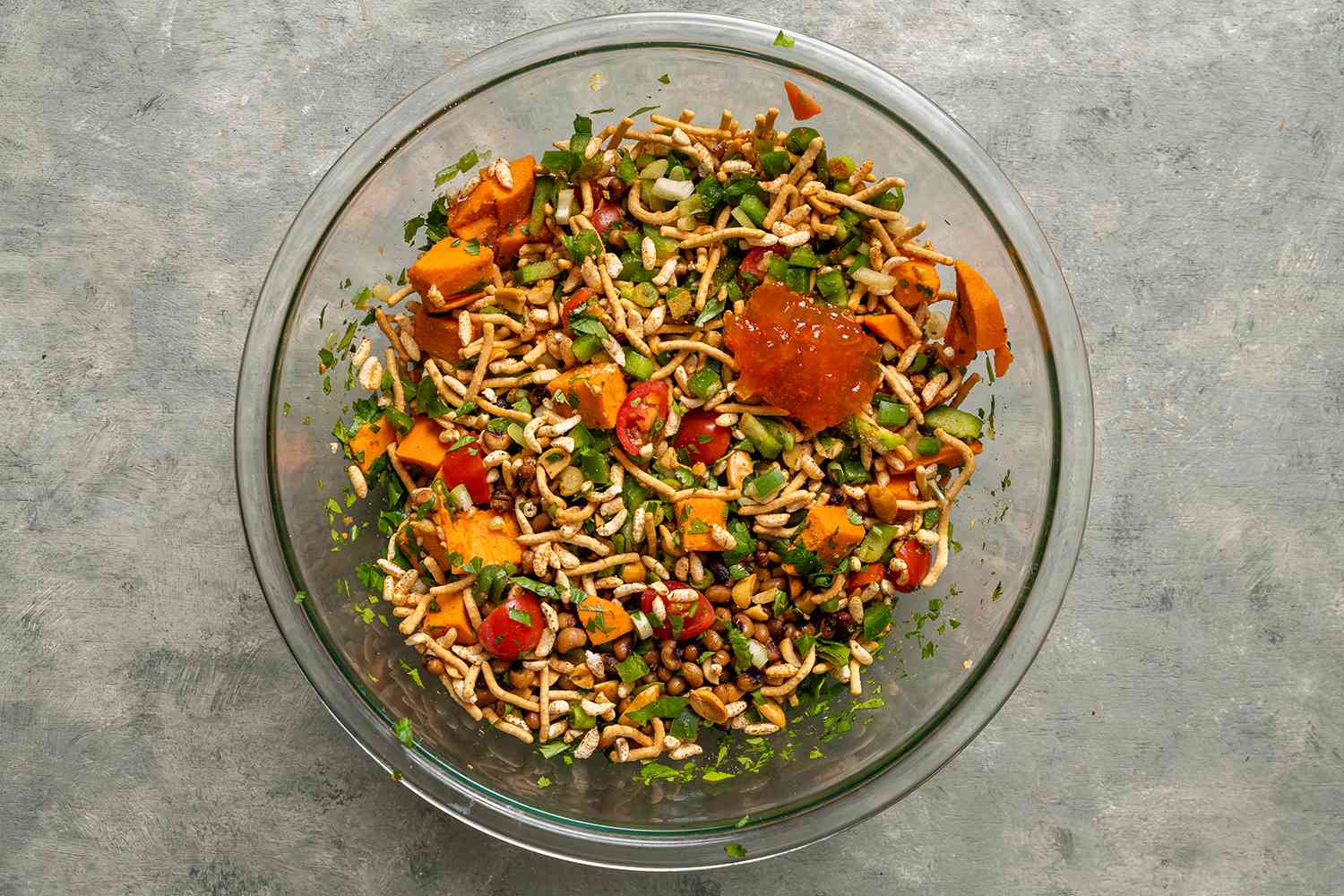 Peanuts and Peas Bhel Puri in a glass bowl, with pepper jelly 