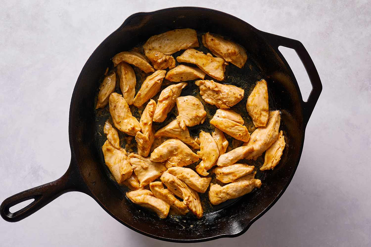 Chicken cooking in a cast iron skillet 