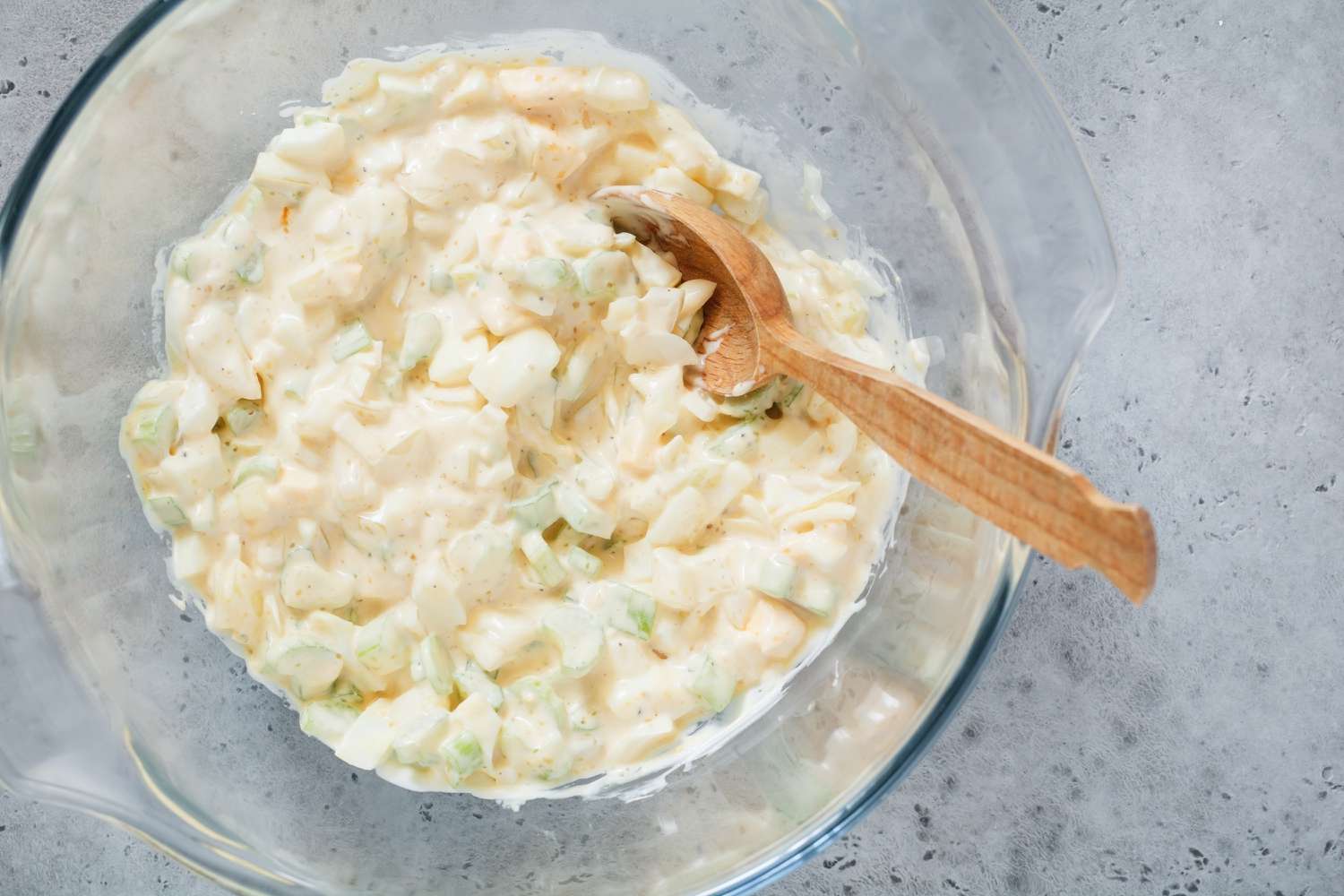 Eggs, celery, mayonnaise, and condiments combined in a bowl