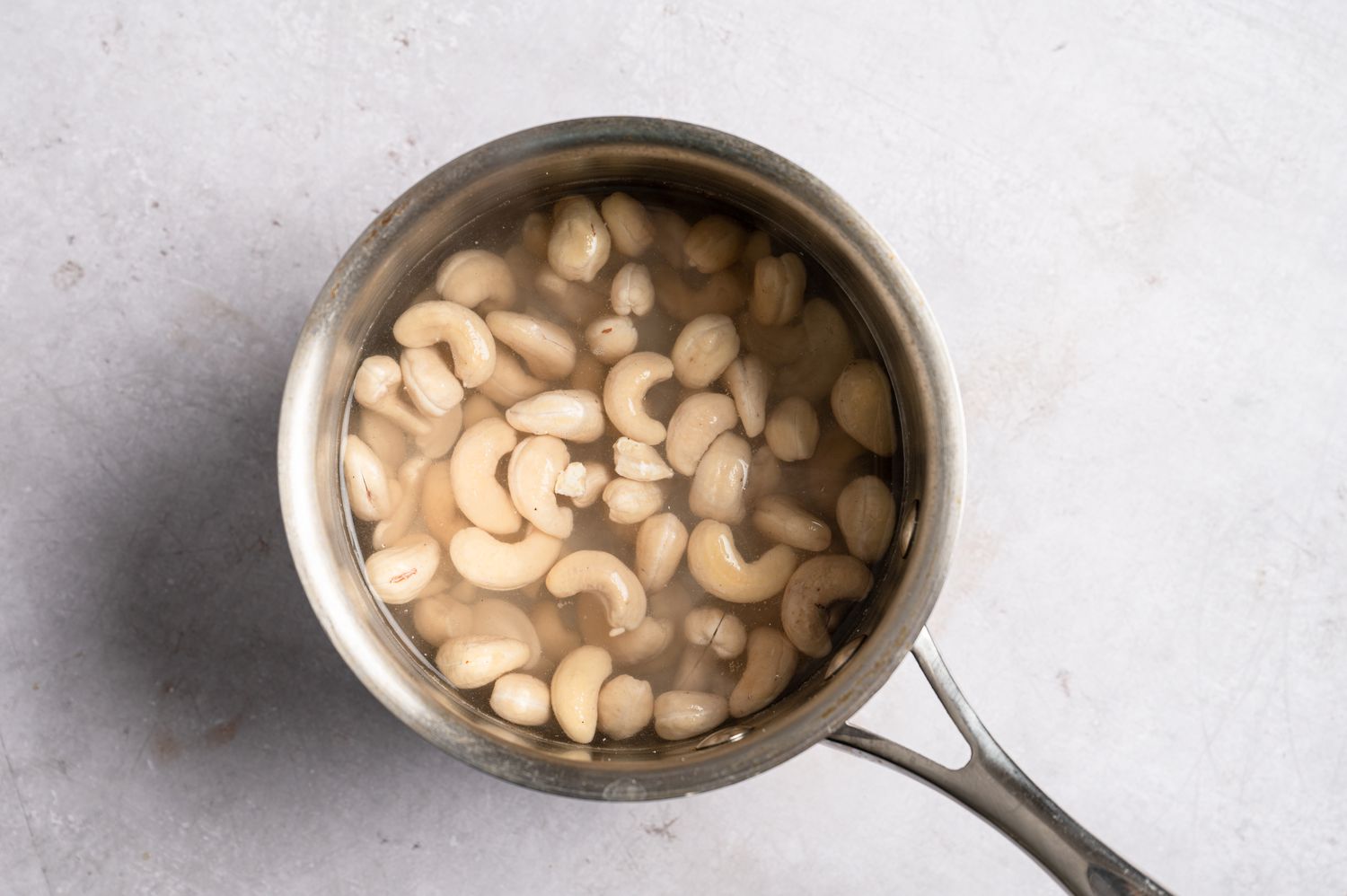 A saucepan with cashews in water