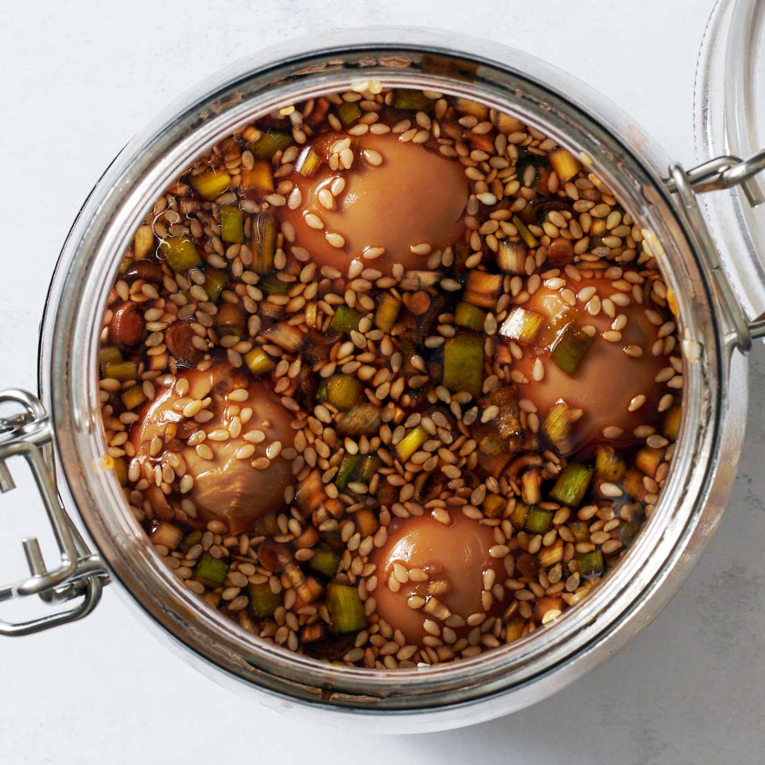 Hard boiled eggs covered with a soy sauce marinade in a jar
