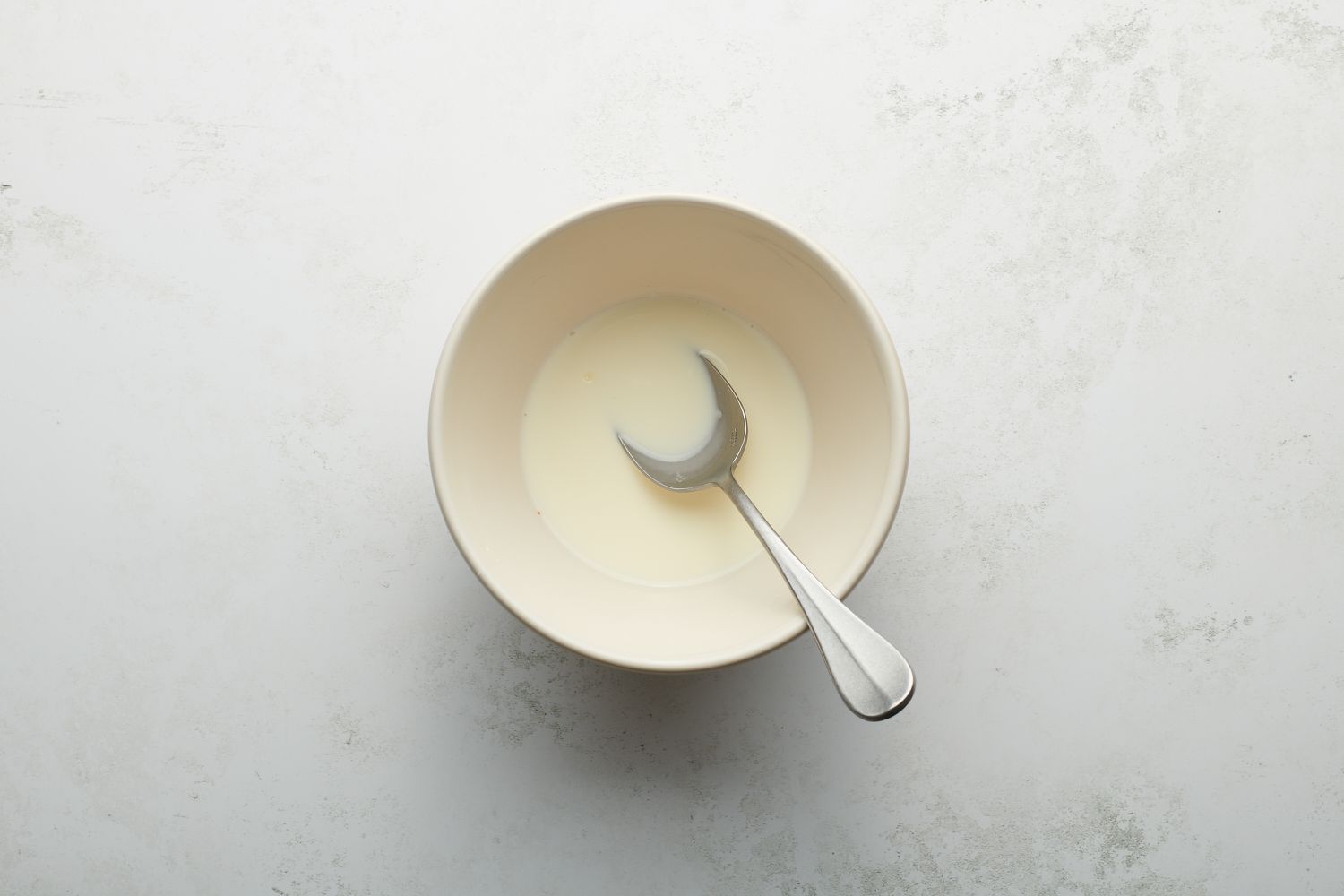 milk and cornstarch in bowl with spoon