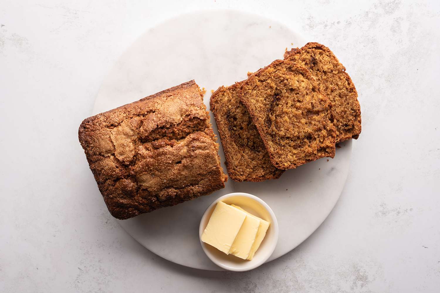 Quick Amish Cinnamon Bread sliced on a platter with butter 