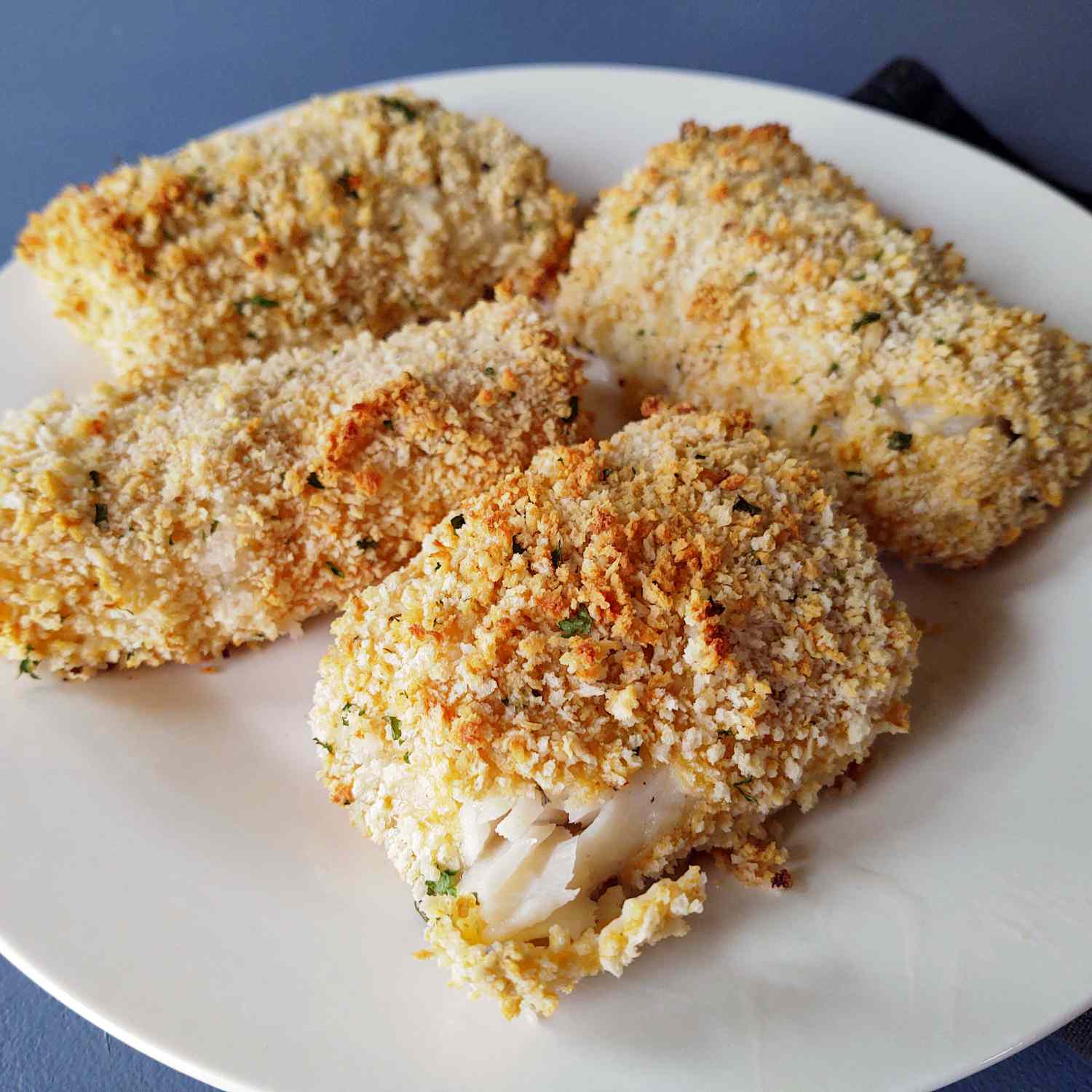 Panko-crusted oven fried haddock on a white plate