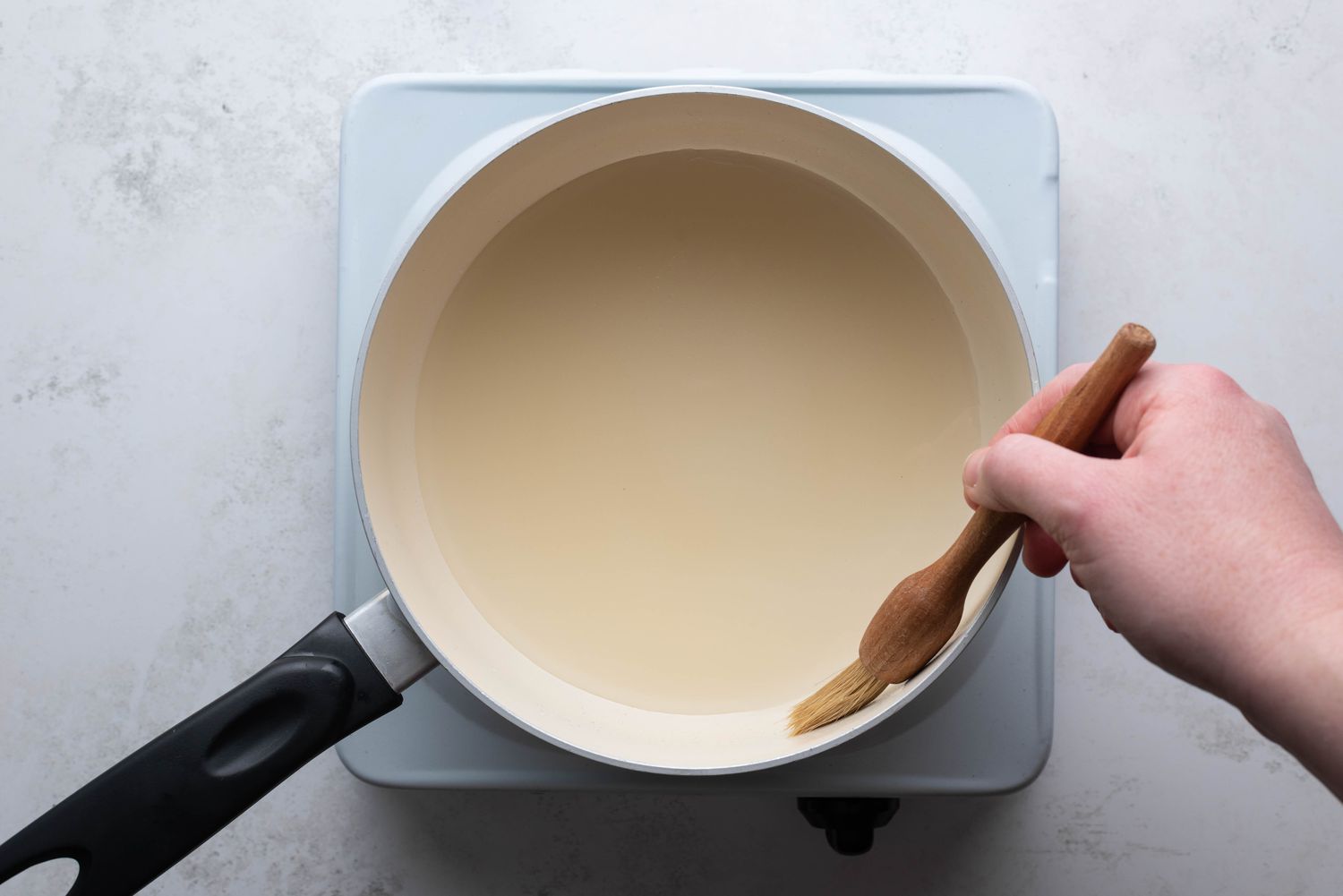 brushing side of sauce pan with water