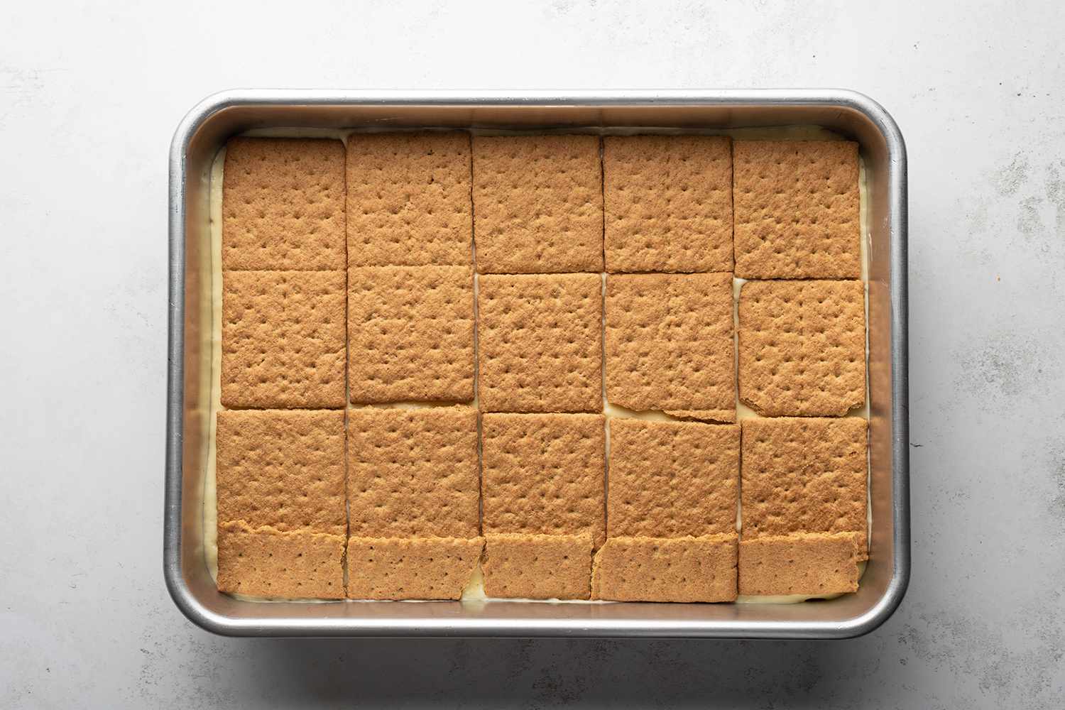 Baking dish with graham crackers on top a pudding mixture 