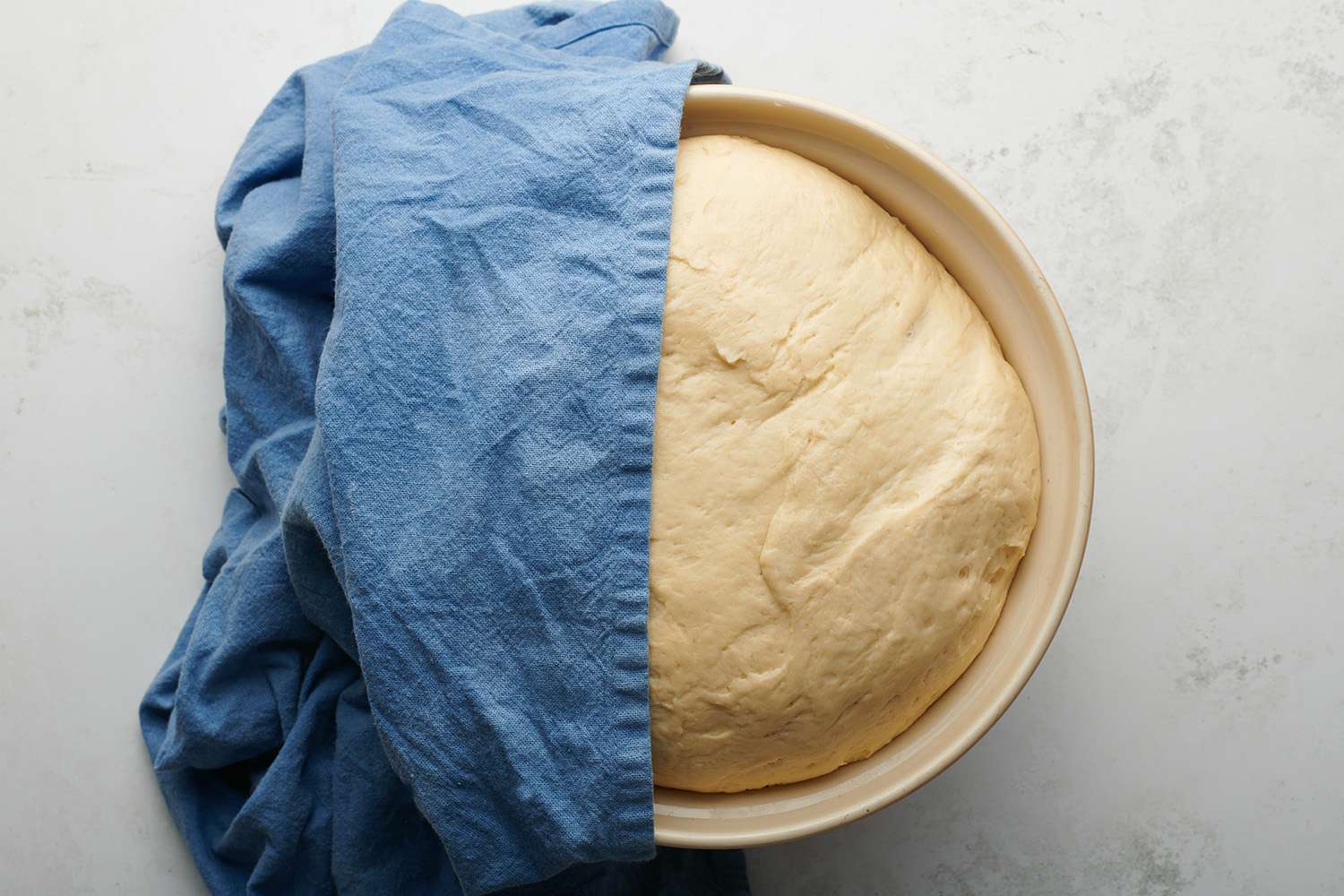 Dough in a bowl, covered with a towel 