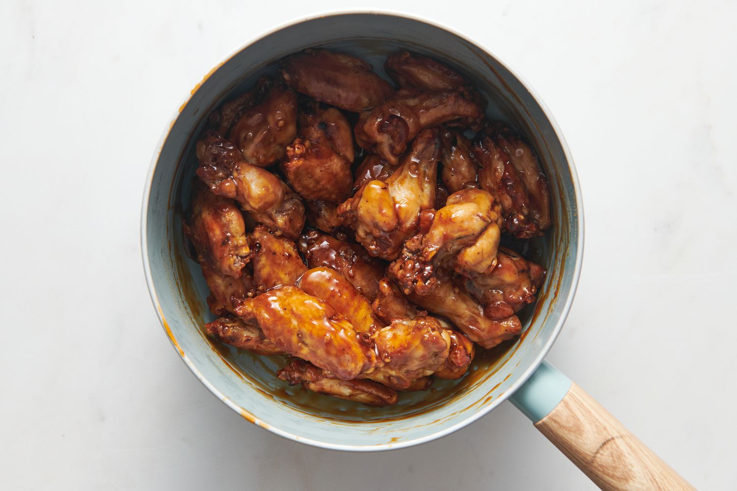 A pan of cooked chicken wings tossed in honey-garlic sauce