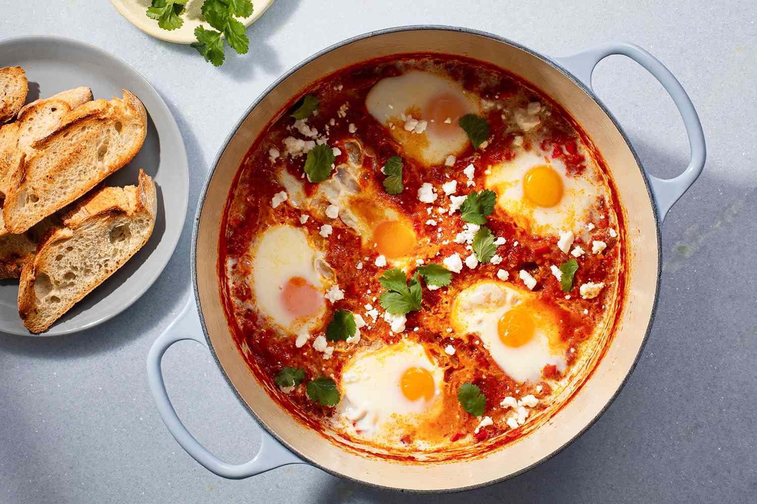 Shakshuka in a pot, served with a side of toasted bread 