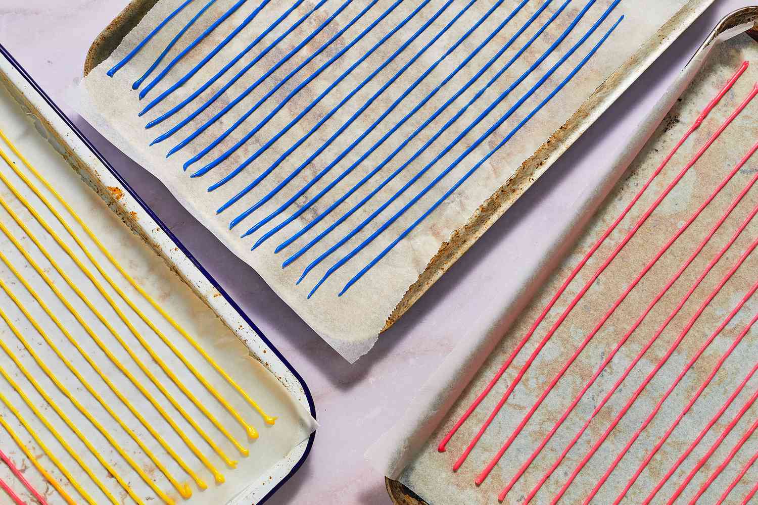 Parchment-lined baking sheets with long lines of piped sprinkle batter