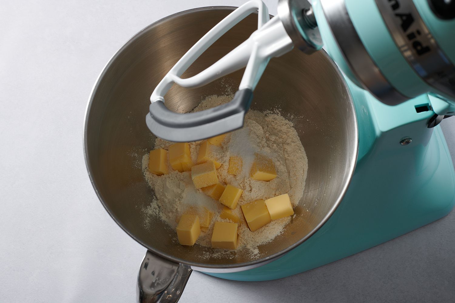 cubes of butter in flour in a stand mixer