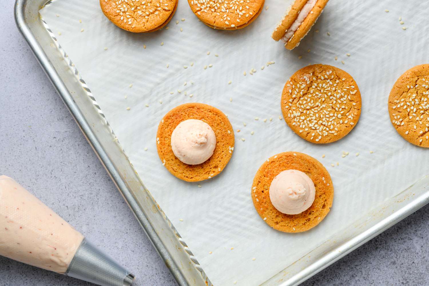 piping strawberry filling into miso peanut butter sandwich cookies