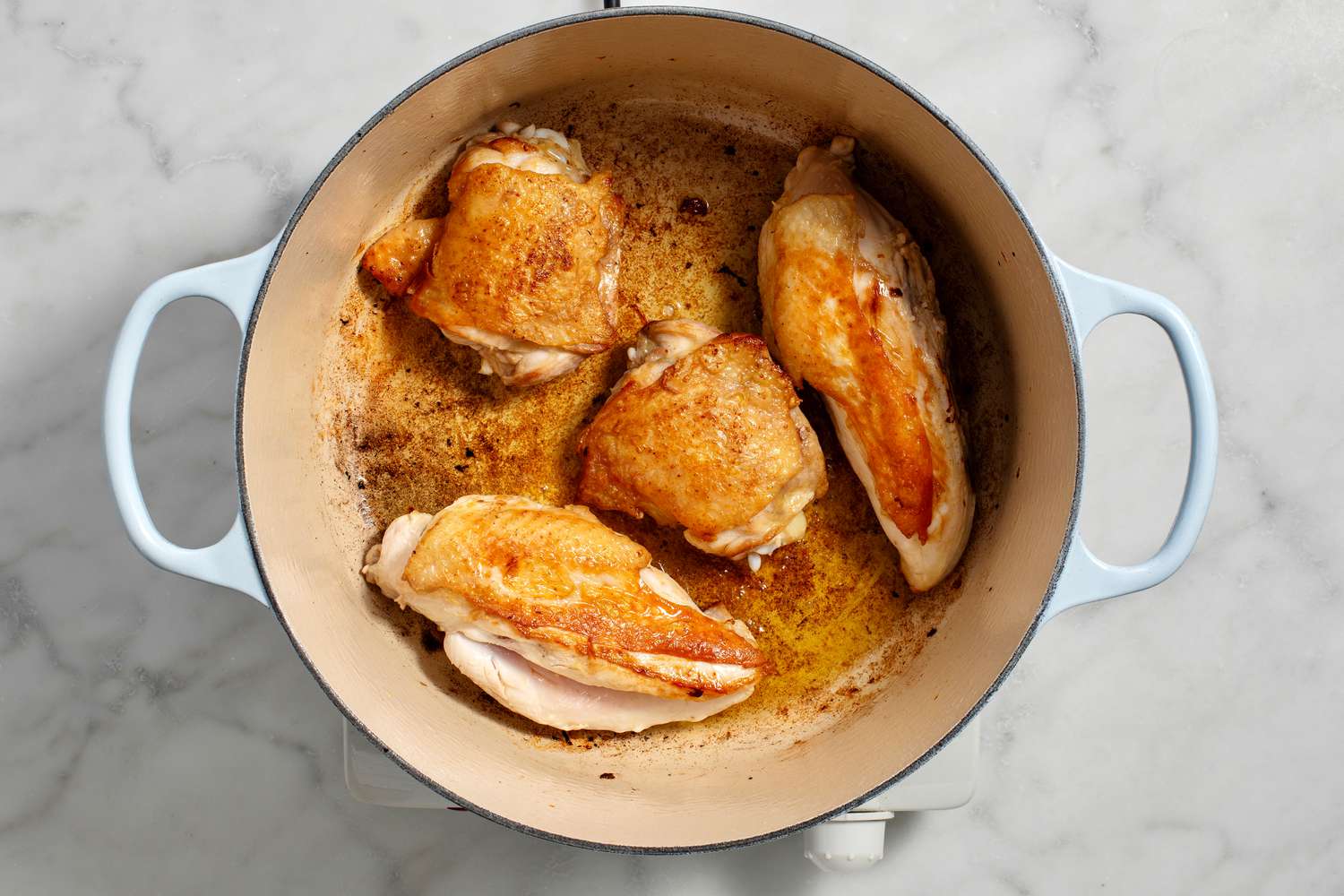 chicken pieces browning in pot