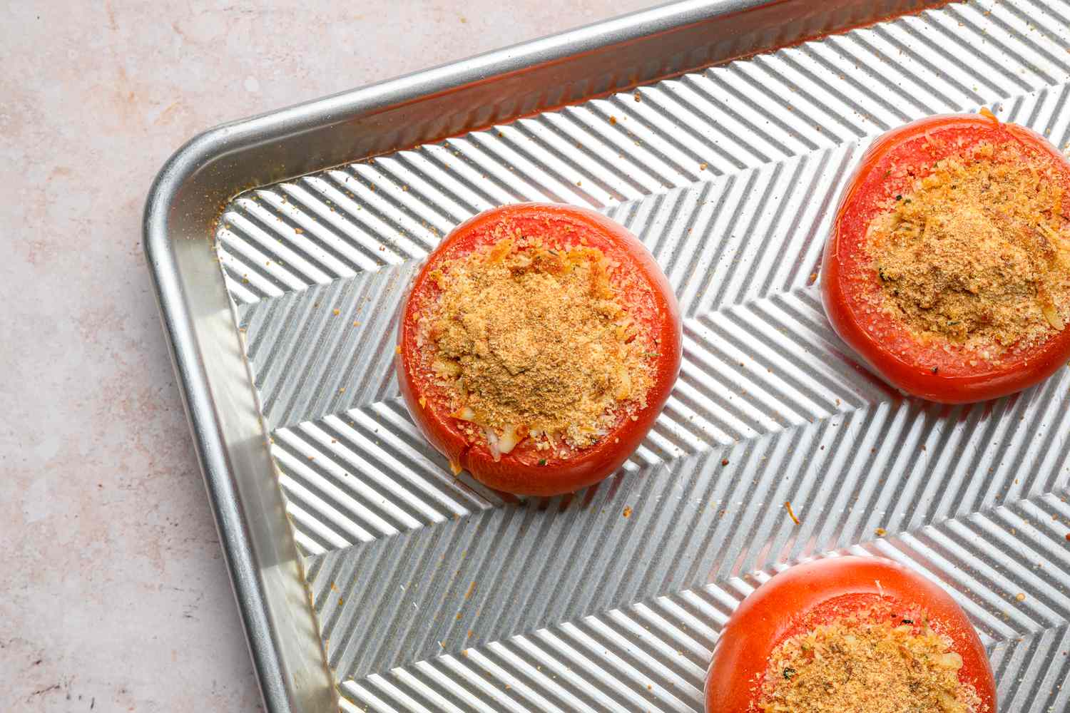A baking sheet with cooked, vegetarian stuffed tomatoes