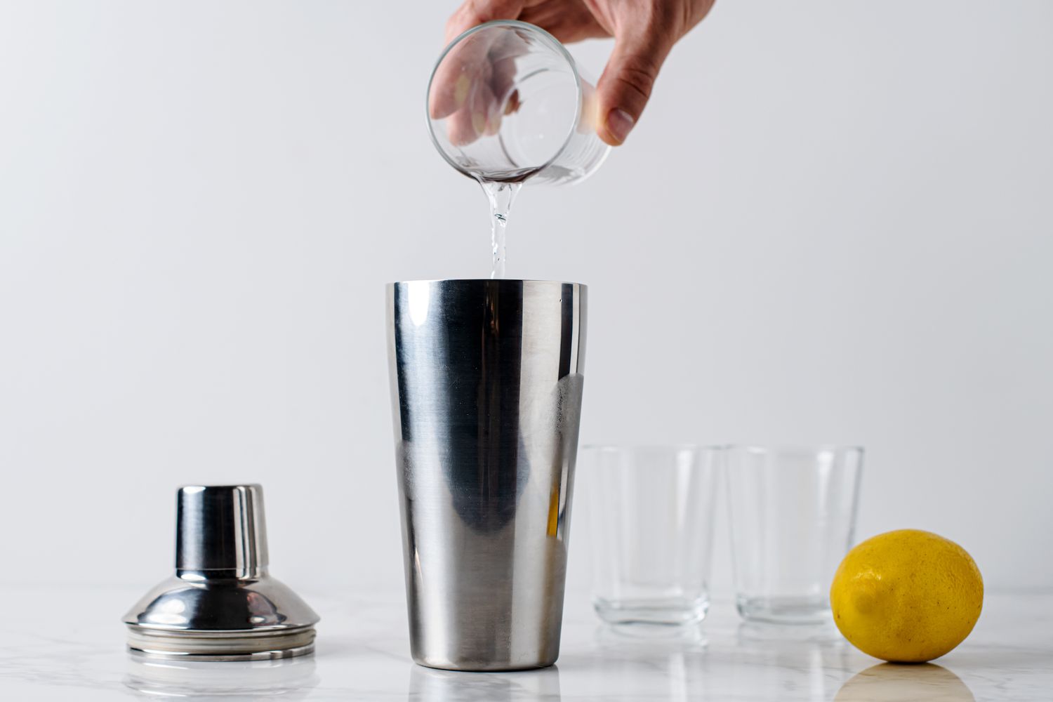 Ingredients being poured into the cocktail shaker for James Bond's Vesper martini