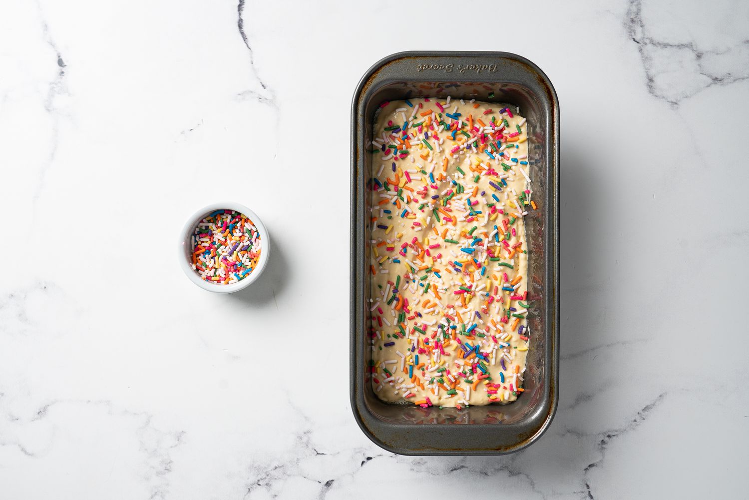 Ice cream bread in a loaf pan covered with sprinkles