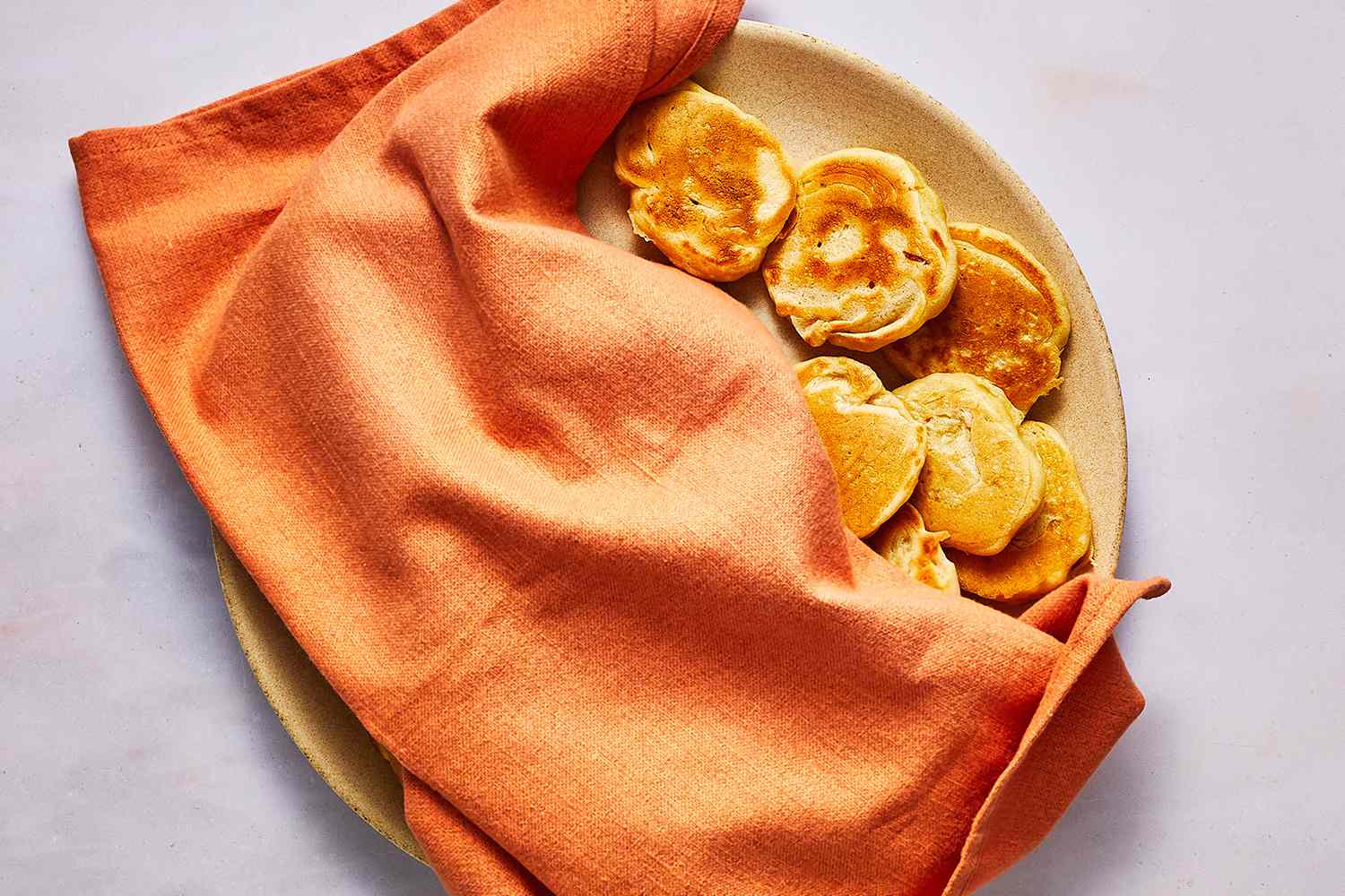 blini on plate covered with orange towel