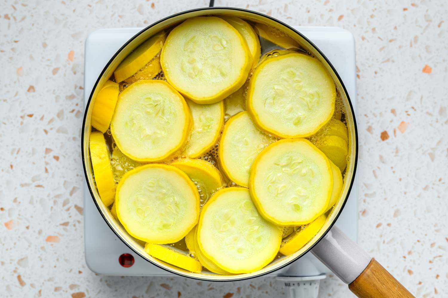 A large pan of sliced squash in boiling, salted water