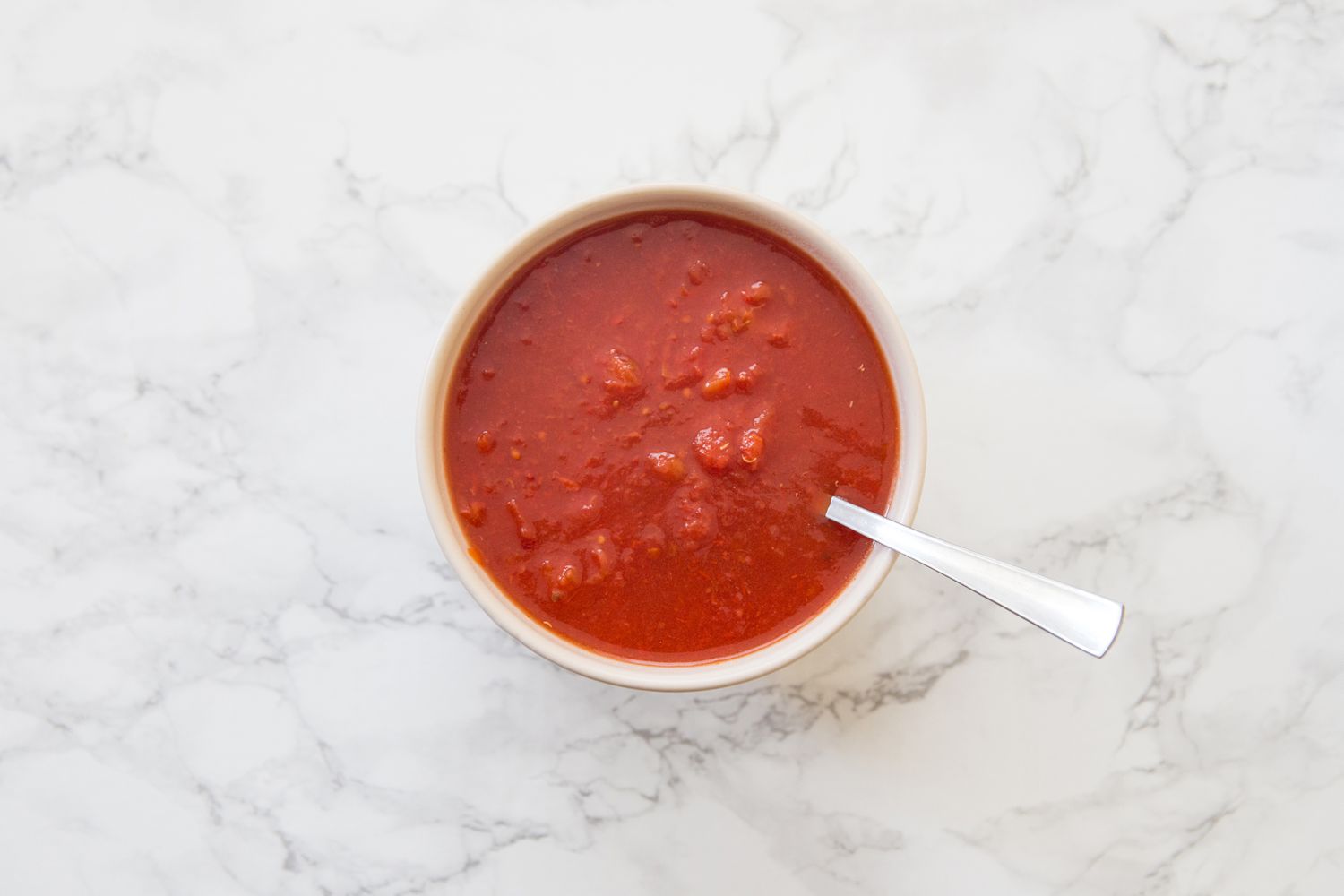 Tomato sauce for stuffed cabbage rolls in a bowl with a spoon