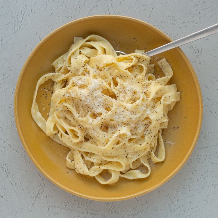Fettuccine enrobed in a creamy alfredo sauce and garnished with grated pecorino Romano and black pepper