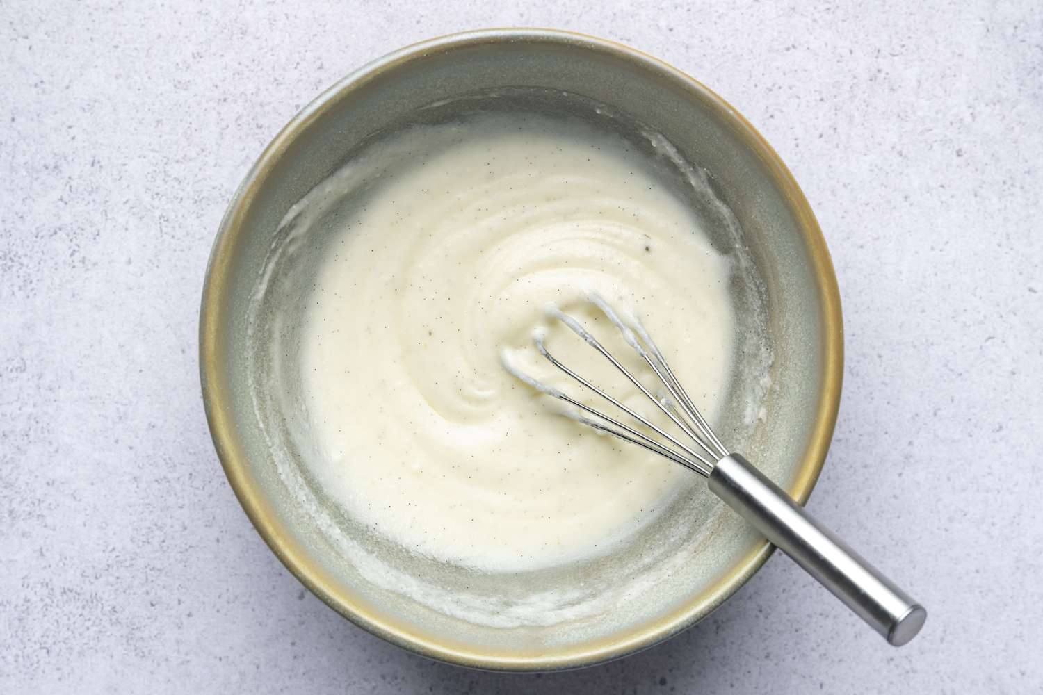 A bowl of glaze with a whisk