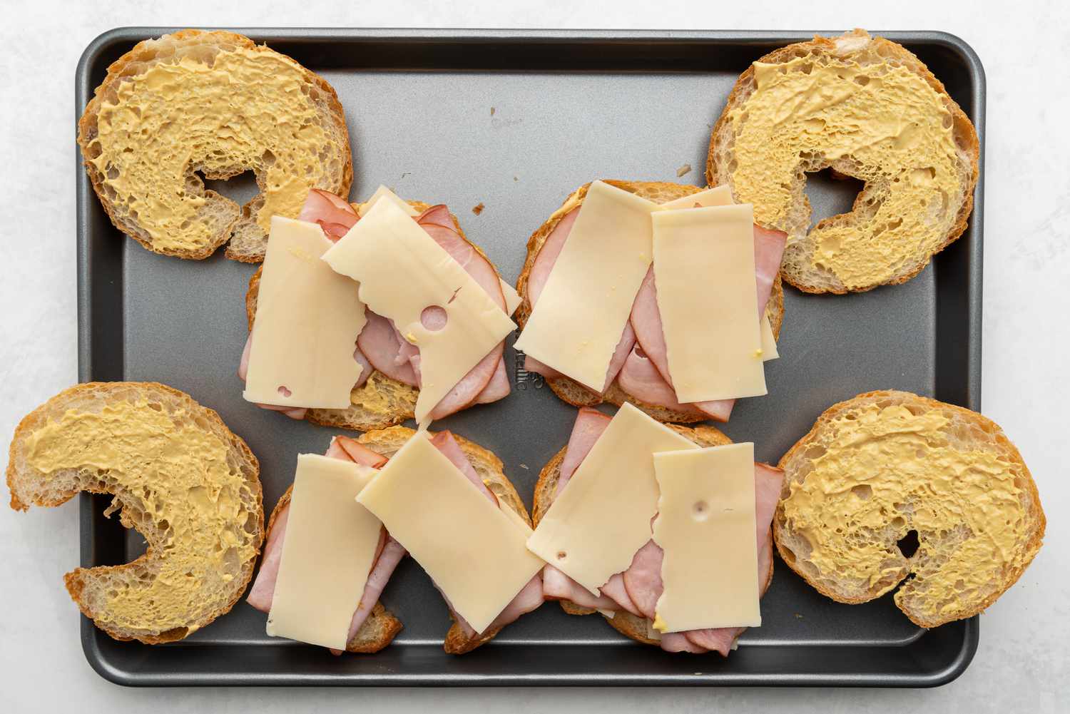 Assembling ham and cheese croissants on a baking sheet