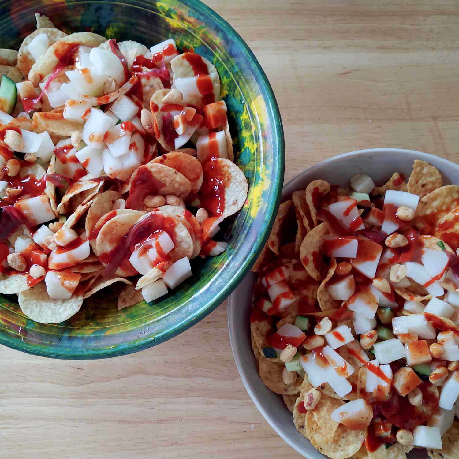 Tostitos in bowls topped with pickled coconut cueritos, peanuts, cucumber, hot sauce, chamoy, and TajÃ­n