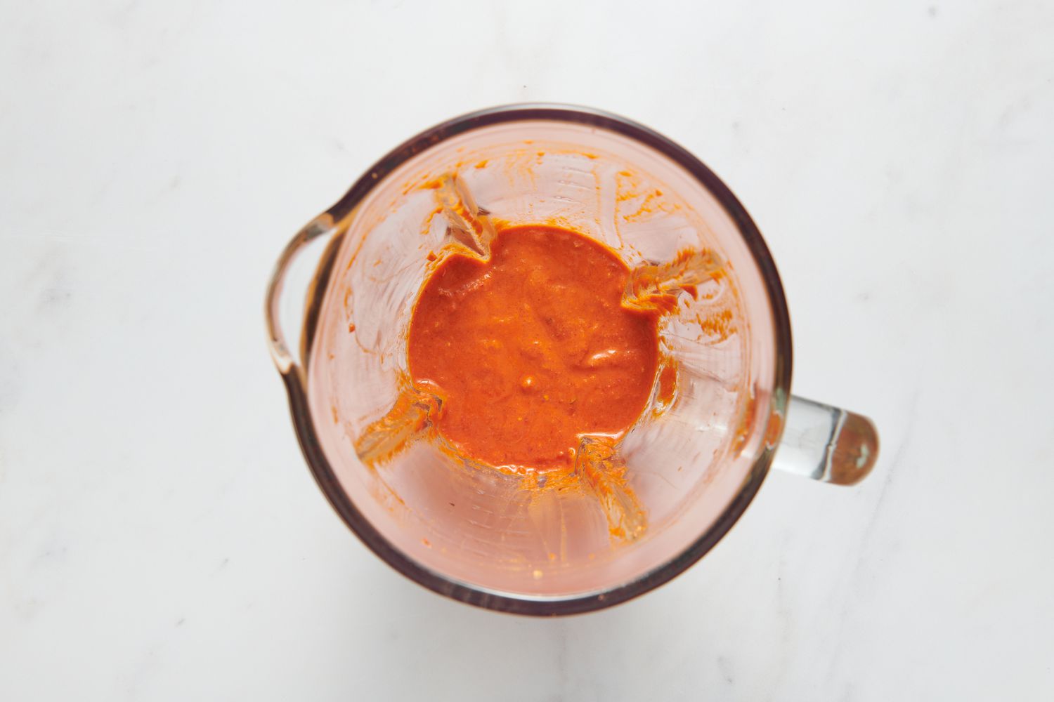 A blender pitcher with smooth romesco sauce