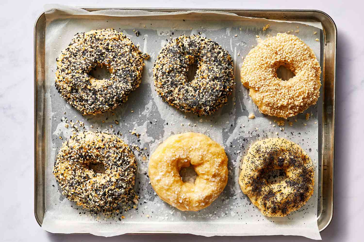 Bagels with toppings on a baking sheet 