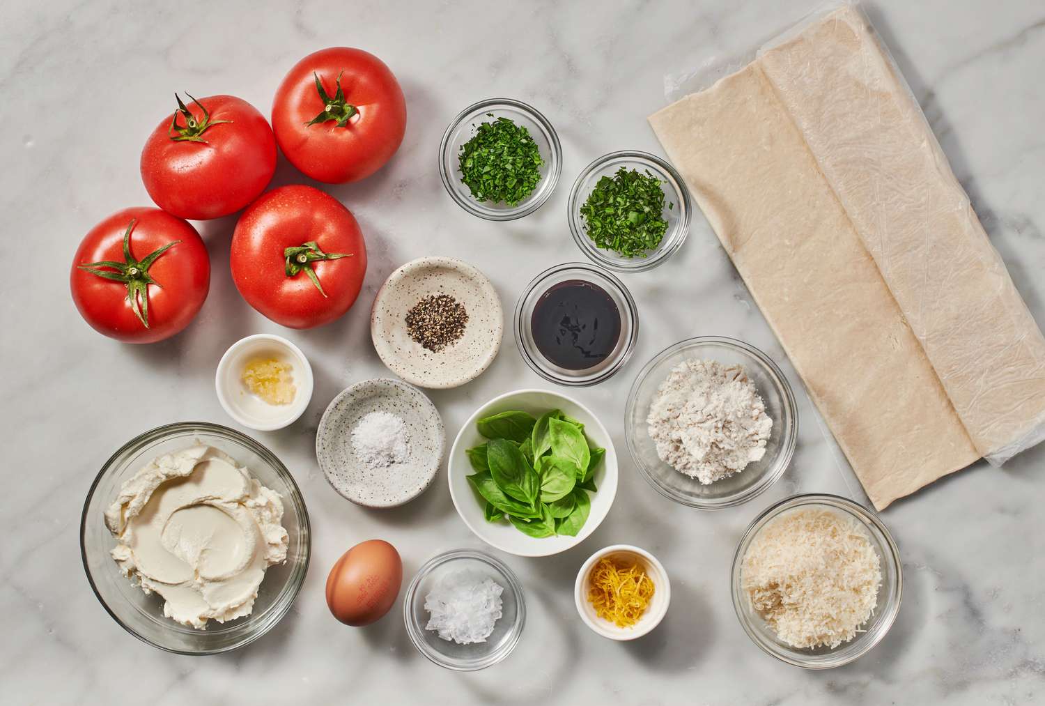 Ingredients to make a tomato tart with puff pastry 