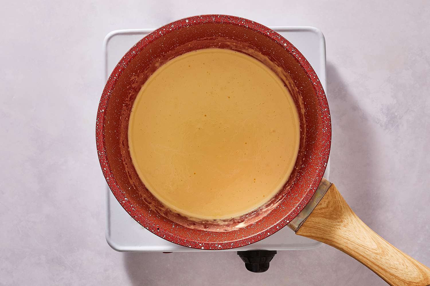 Cream in a saucepan on a burner 