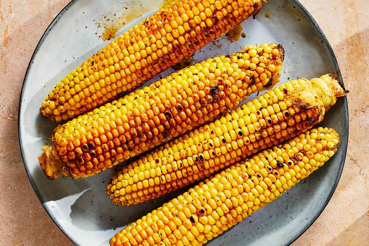 A platter of grilled cajun-style corn on the cob
