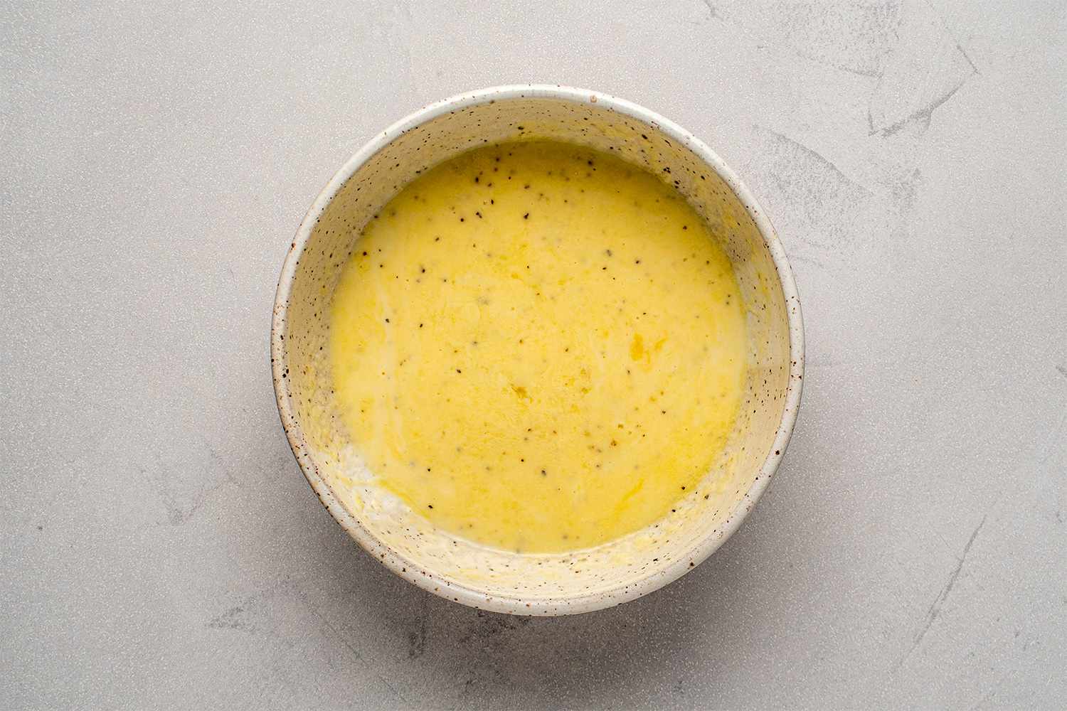 Egg, buttermilk, salt and pepper in a bowl 